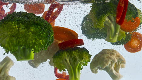 raw vegetables dropped water on white background closeup. fresh veggies floating