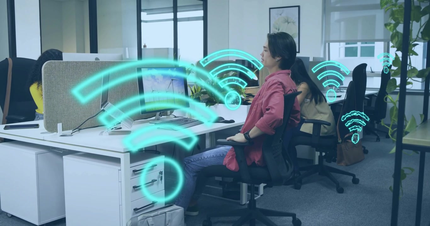 Un impiegato che nota un'icona Wi-Fi luminosa sotto la scrivania, si allunga e poi digita mentre le onde di segnale crescono.