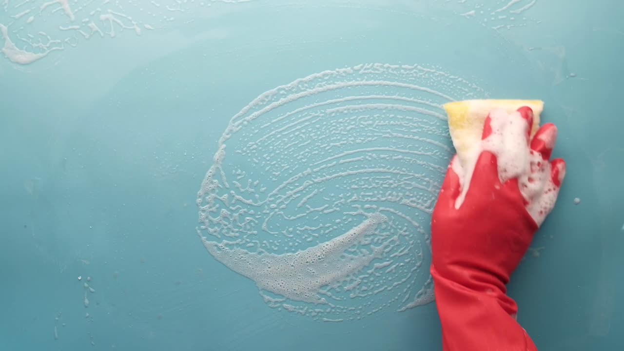 스폰지 와 비누 로 밝은 파란색 표면 을 청소 하는 것