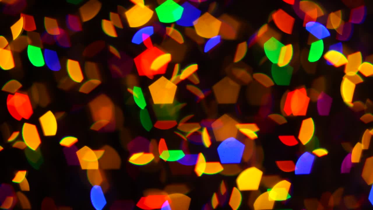 다채로운 크리스마스 추상적인 보케는 어두운 배경에서 아름답게 박이고 초점을 맞추지 않습니다.