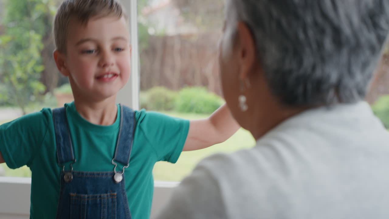 un niño lindo abrazando a la abuela sonriendo abrazando a su nieto abuela feliz disfrutando del abrazo de su nieto en casa concepto familiar 4k