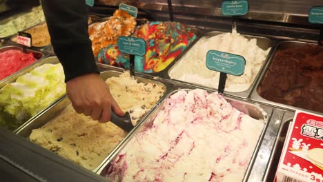 hand scooping ice cream at a shop