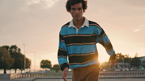handsome guy training longboard outdoor closeup. focused skater enjoying street