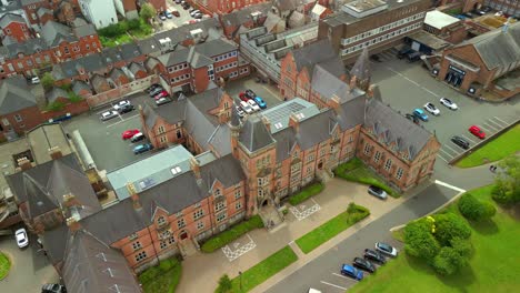 wide reversing aerial video of methodist college belfast, in northern ireland, uk on a bright and sunny day. filmed in 4k, 60fps and with rec709 color.