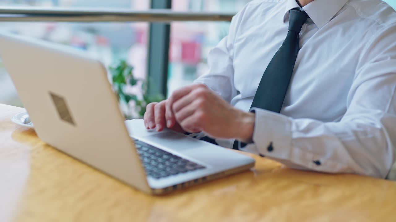 Thoughtful senior man working on a laptop. Portrait of a mature grey-haired businessman sitting near the window and working in the office.