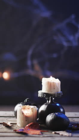 vertical video of halloween candles, pumpkins and smoke with copy space on blue background