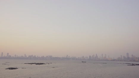 Paisaje-Urbano-De-La-Playa-Marina-Costera-De-Mumbai-Al-Atardecer-Con-Edificios-De-Lujo-En-El-Horizonte-Por-La-Noche-Con-Aire-Pobre-T,-Tiro-De-Gran-Angular,-India