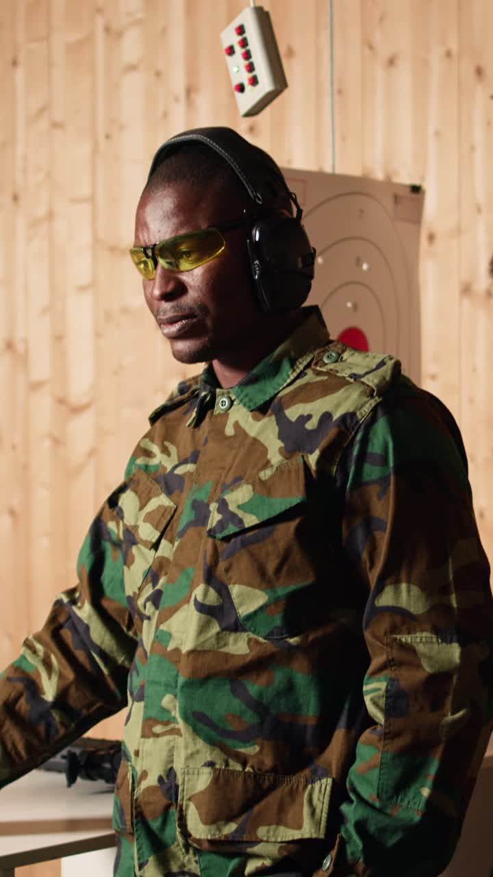 Vertical video Portrait of happy army soldiers in shooting gallery comparing targets shot