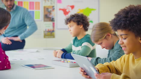 estudiante de primaria en el aula estudiando modelos moleculares en la clase de ciencias con una tableta digital