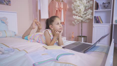 una niña pensativa haciendo la tarea en casa.