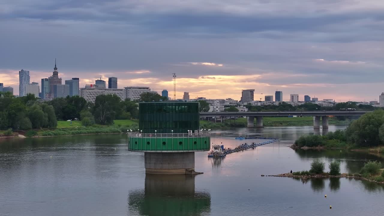 Golden hour over Warsaw! Stunning drone flight from the river to the city skyline with glowing skyscrapers and breathtaking sunset views