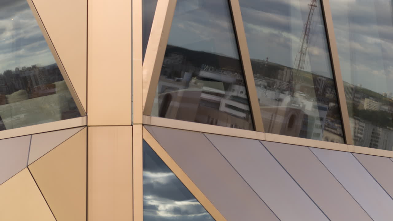 기하학적 패턴과 유리 반사와 함께 현대적인 건물 전면 세부 사항