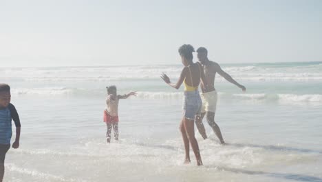 Afroamerikanische-Familie-Genießt-Gemeinsam-In-Der-Nähe-Der-Wellen-Am-Strand