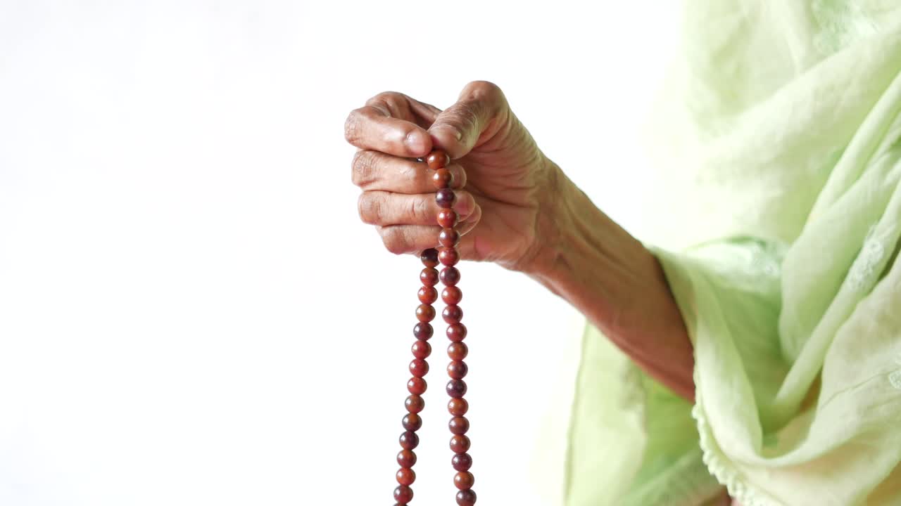 기도 구슬 을 들고 있는 노인 여자