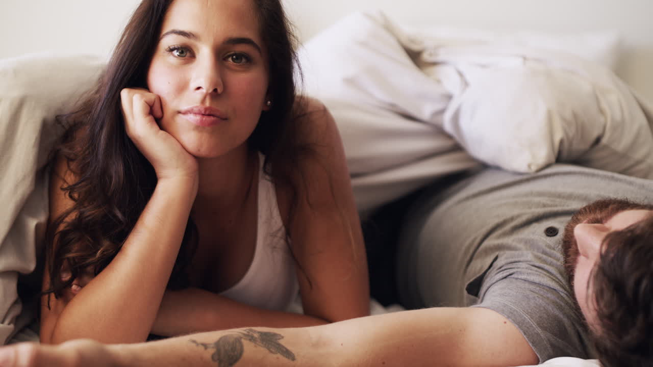 Happy, relax and young couple in bed on a lazy