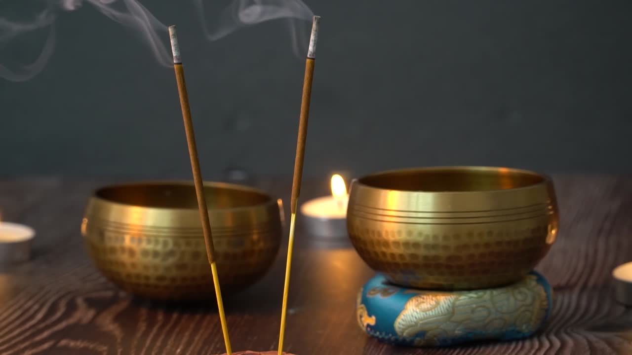 Incenso che brucia con candele e ciotole tibetane.