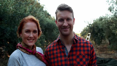 smiling couple standing in olive farm