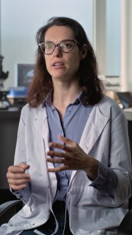 mujer científica haciendo una presentación o discusión en un entorno de laboratorio