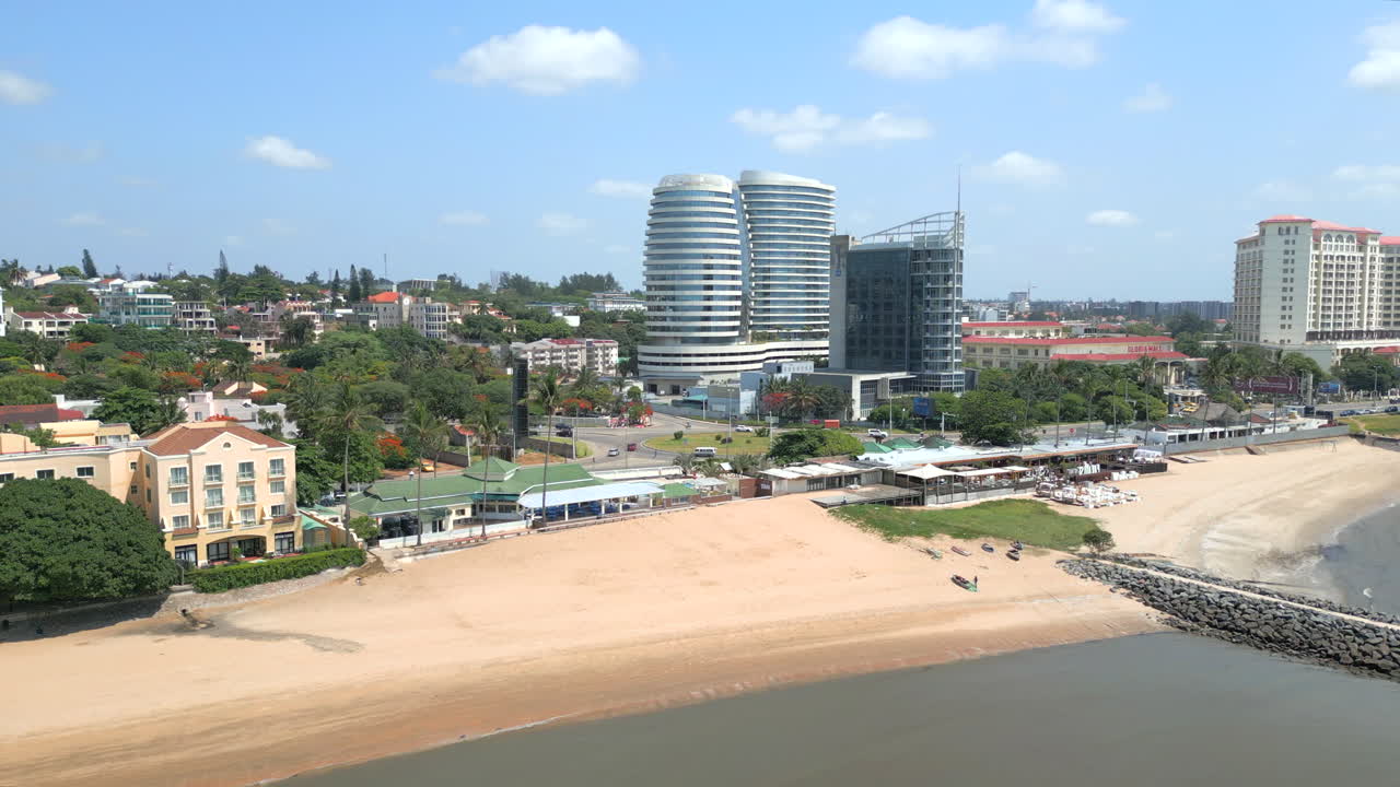 maputo, mozambique - una pintoresca vista de modernos edificios frente a la playa frente al cielo azul claro - fotografía aérea de un dron