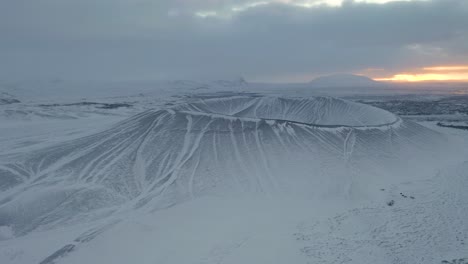 aerial drone shot of snowy hverfjall crater during mystical sunset in background - iceland,europe