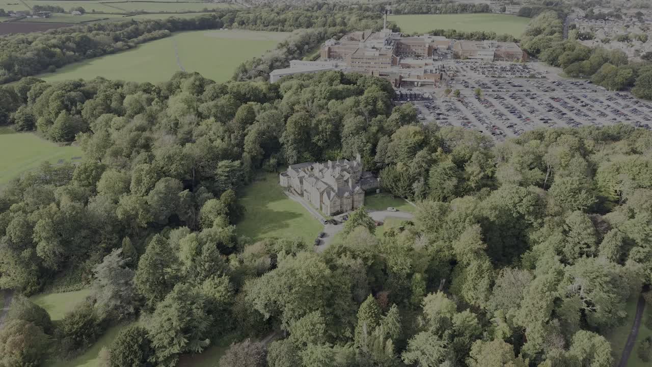 Historic and grand Arrowe Hall (now care centre) drone approach from far on a sunny autumnal afternoon - Wirral, UK