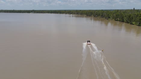 boat towing waterskier on a scenic river