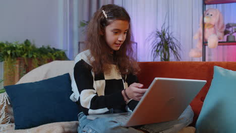 girl sitting on home couch, looking at camera, making video conference call with friends or family