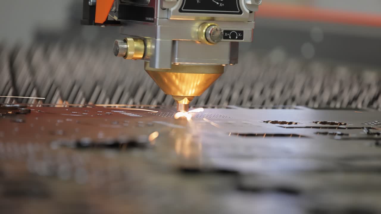 Taglio laser CNC del metallo, moderna tecnologia industriale. Profondità di campo ridotta. Avvertimento: riprese autentiche in condizioni difficili.