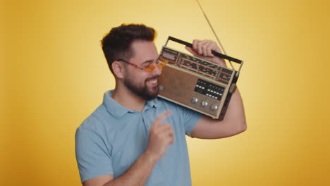 hombre feliz usando reproductor de cinta retro para escuchar música discoteca bailando de su canción favorita divirtiéndose