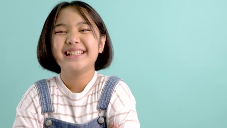 slow motion happy asian girl smiling and laughing in front of green screen