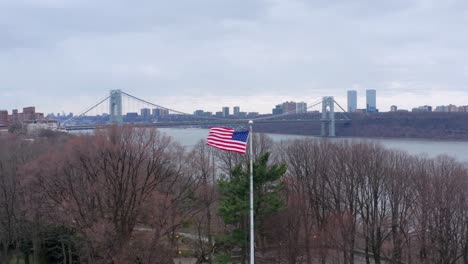 american flag waving in the wind beside hudson river, new york