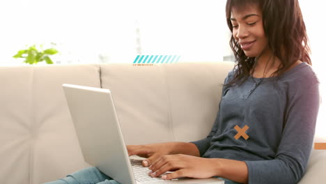 animación de formas sobre una mujer biracial usando una computadora portátil