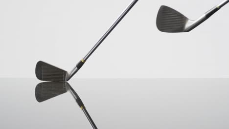 close up of golf clubs on white background, copy space, slow motion