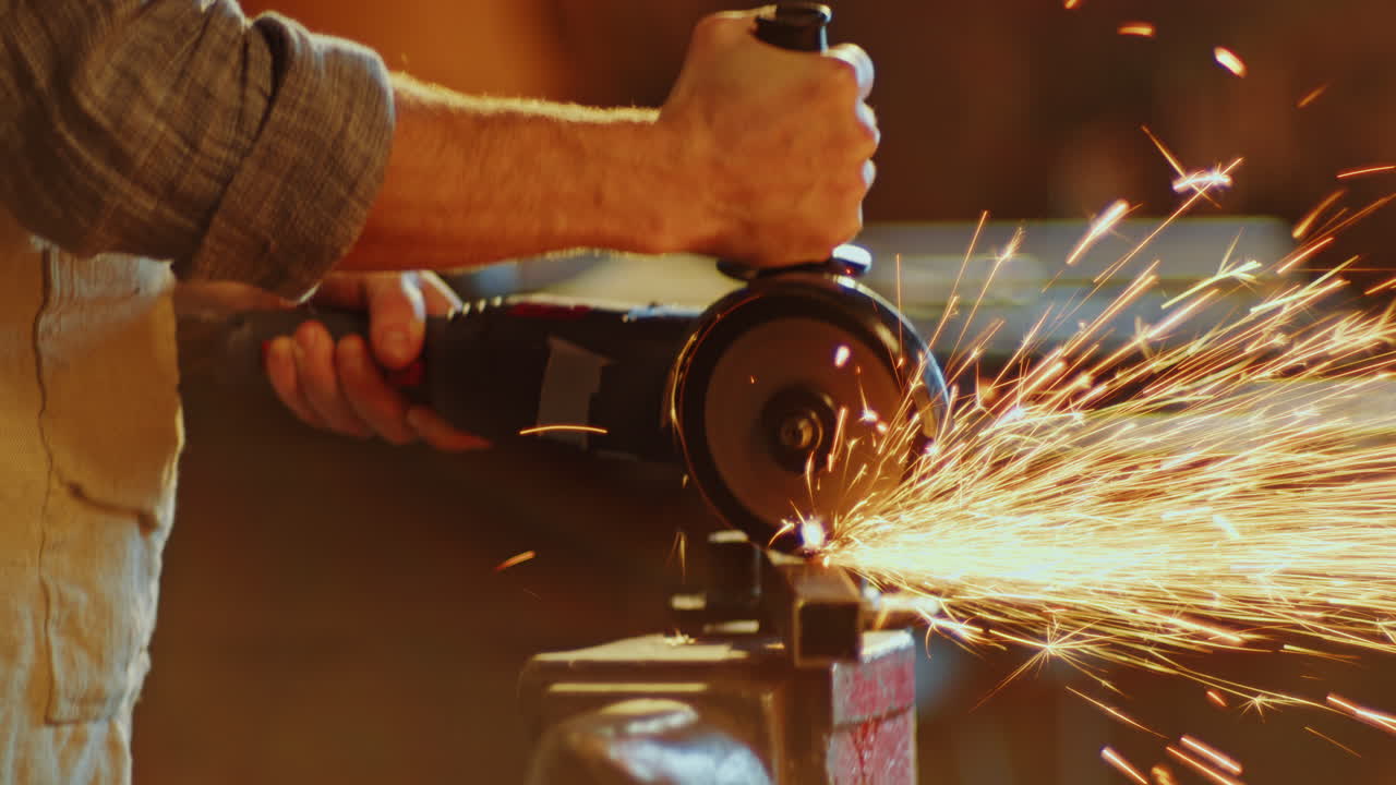 primer plano de un herrero cortando una barra de metal con una molienda angular