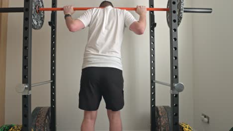 static shot of a man unracking the bar and starting to squat the weight