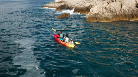 dos amigos remando un kayak cerca de los acantilados en pula, istria, croacia - toma aérea