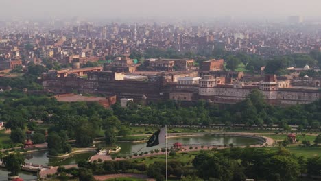 pakistan flag waves as drone descends, lahore fort in background. top tourist attraction