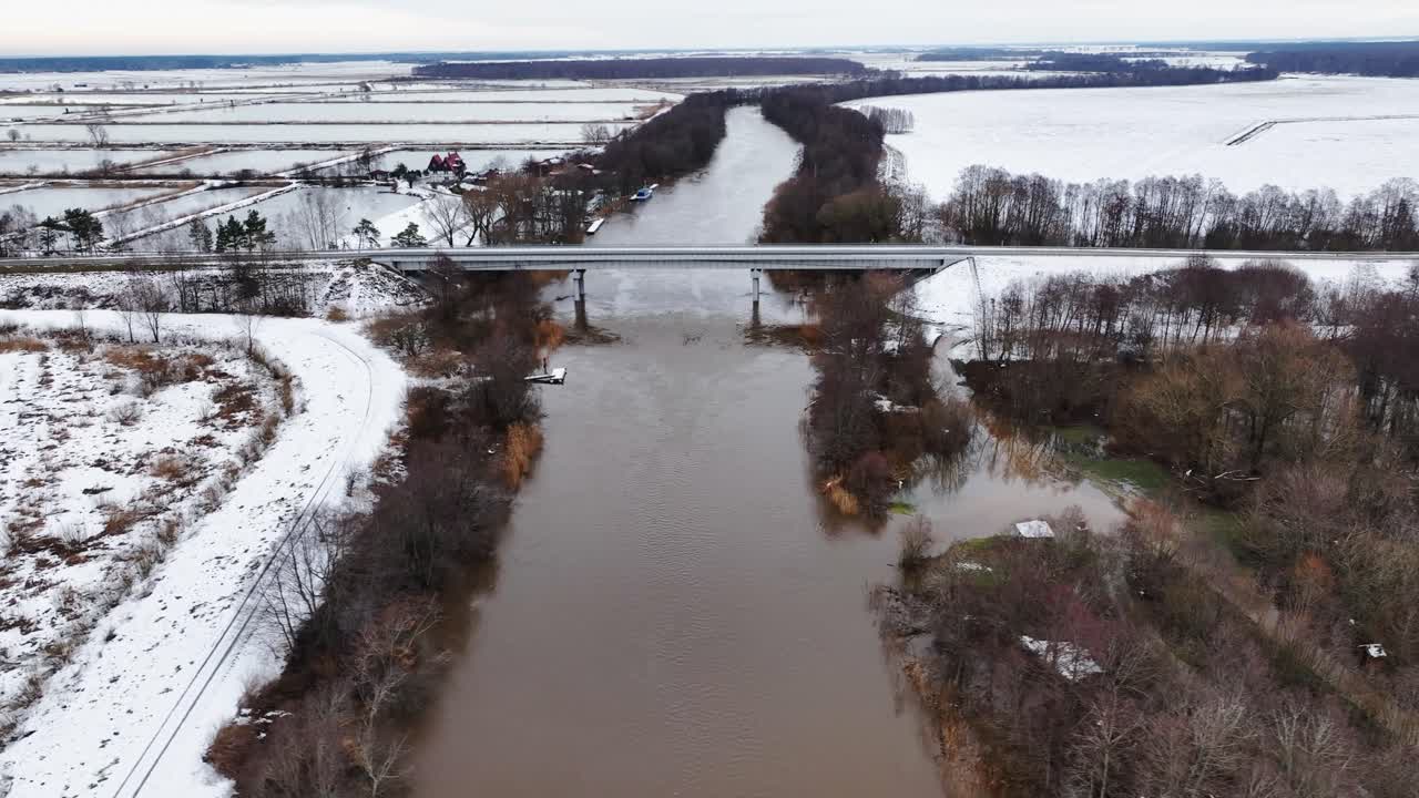 A bridge in the countryside is built over a river, which is used by cars in wintertime. Europe Lithuania.