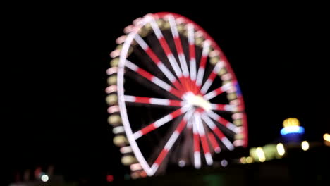 static wide shot showing big blinking ferris wheel at night,out of focus