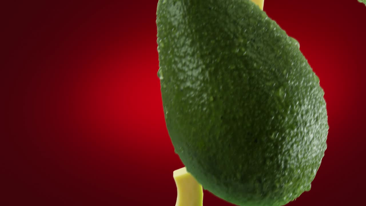 진한 빨간색 배경에 떨어지는 조각이 있는 아보카도