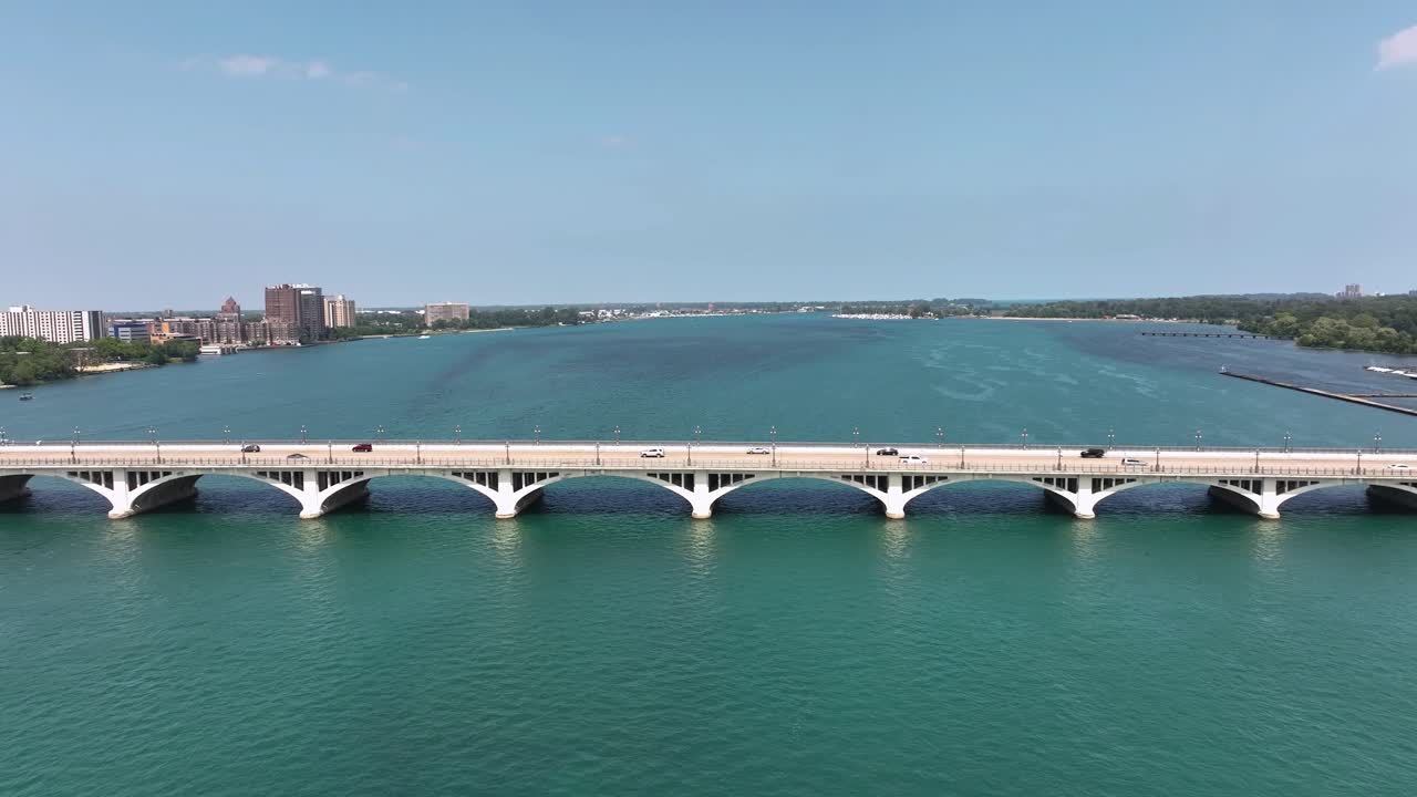 Drone pull back shot revealing the Macarthur Bridge that connects Belle Isle to the mainland in Detroit Michigan