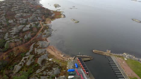 aerial view of sea coast with rocky shore and small dock and empty berths