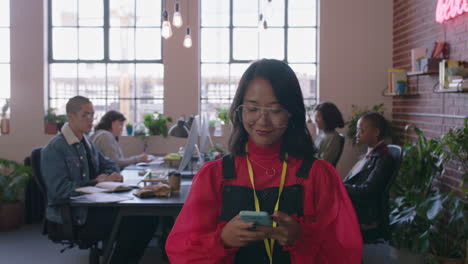 happy-asian-business-woman-using-smartphone-browsing-social-media-messages-texting-on-mobile-phone-enjoying-diverse-office-workplace-female-manager-walking-confident-wearing-glasses