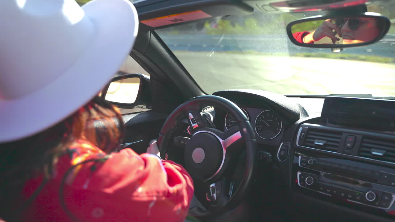 mujer conduciendo un coche descapotable