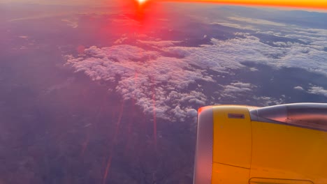 Flugzeugturbinen-Düsentriebwerk-Fliegt-über-Wolken-Mit-Leuchtend-Roter-Sonne,-Sonnenuntergang-Sonnenaufgang-Skyline,-Flugzeug-über-Wolken,-Urlaubsreise,-4K-Aufnahme