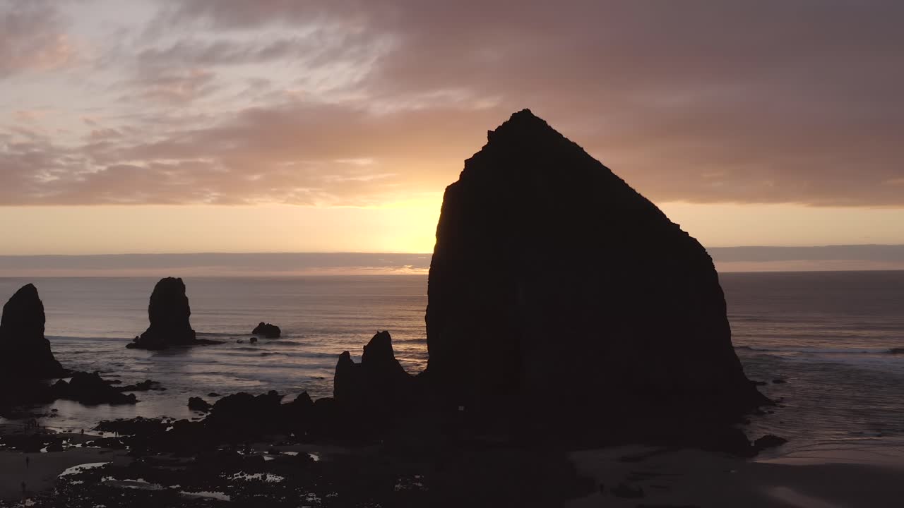 silueta de roca de pajar al atardecer cerca de cannon beach en oregon