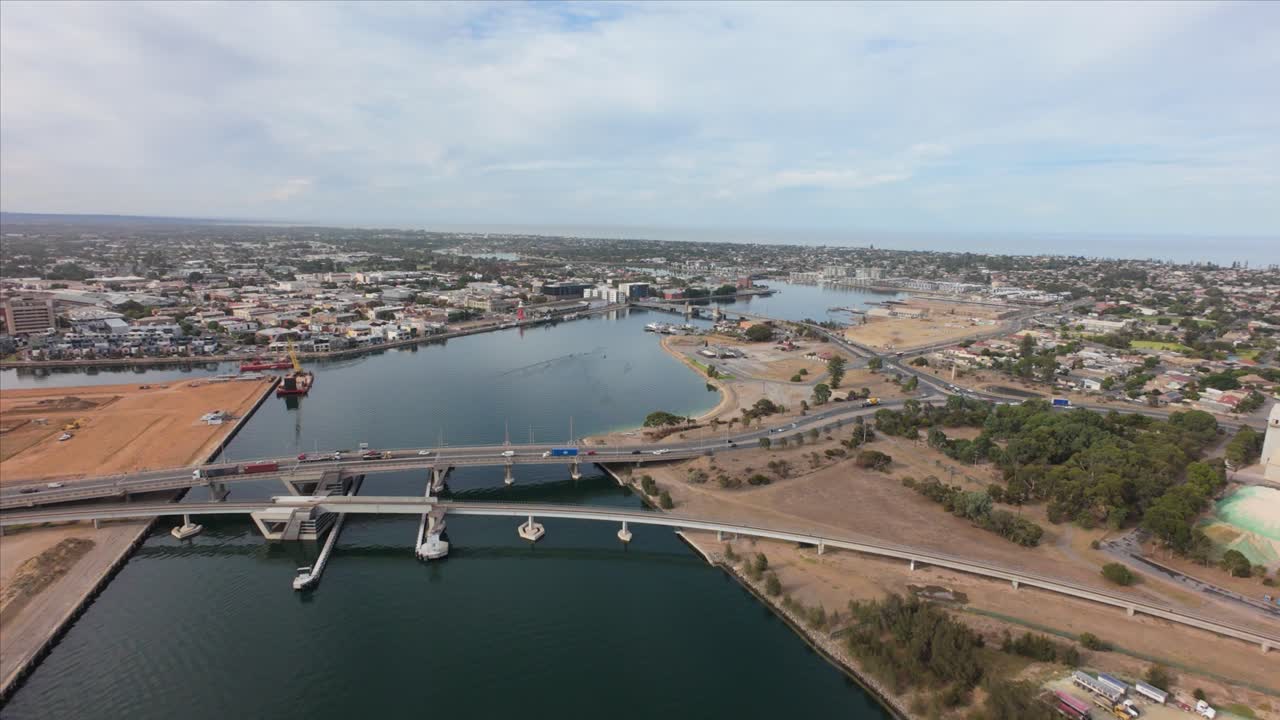 drone view from high showing port adelaide and a bridge with cars running over 4k 50p