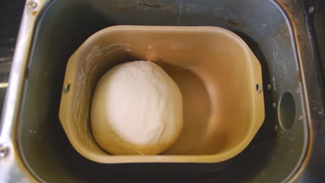 top down view of dough being kneaded in a bread maker