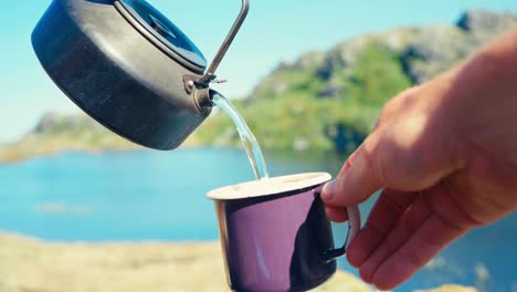 verter agua caliente de la tetera en una taza al aire libre en la naturaleza