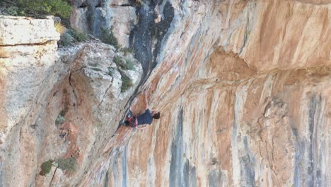 Escalador-Deportivo-Ascendiendo-Por-Una-Pared-Montañosa-Sobresaliente